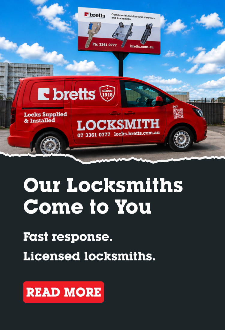 Red locksmith van with 'bretts' branding and a billboard in the background.